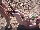 Girl strips guy on the beach