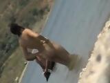 Nubile brunette nudist soaks up some sun on the beach and g